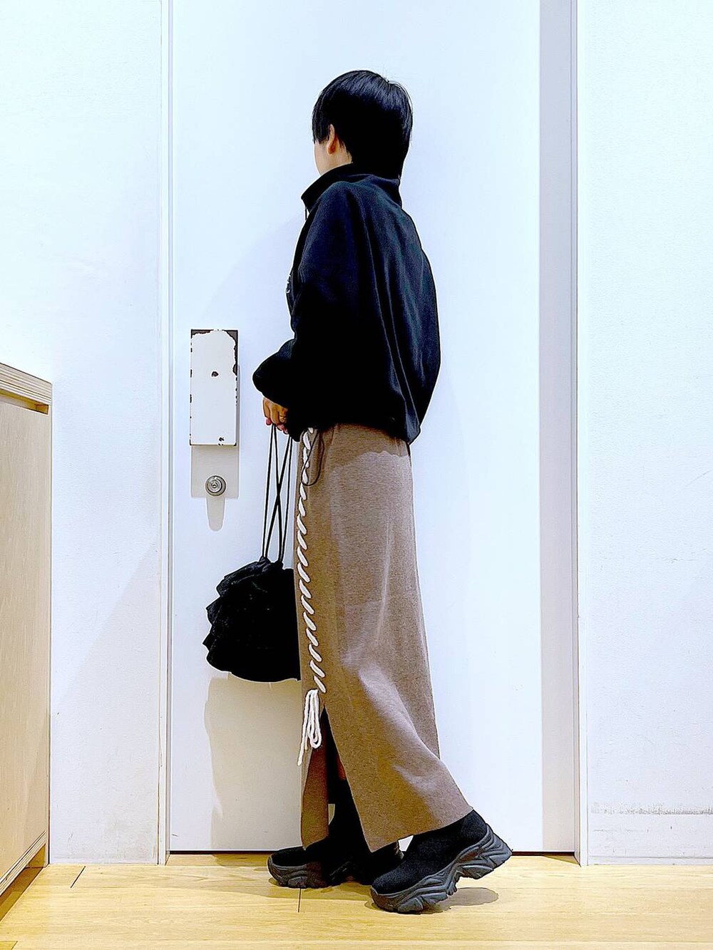 ブラック系のブーツ、ブラウン系のスカート、ブラック系のスウェットを着用したレディースの冬コーディネートの3枚目の写真