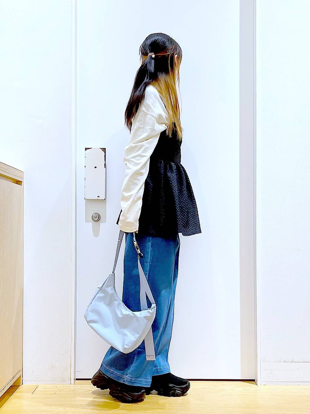 ブルー系のデニムパンツ、ホワイト系のTシャツ/カットソー、ブルー系のショルダーバッグを着用したレディースの春コーディネートの5枚目の写真