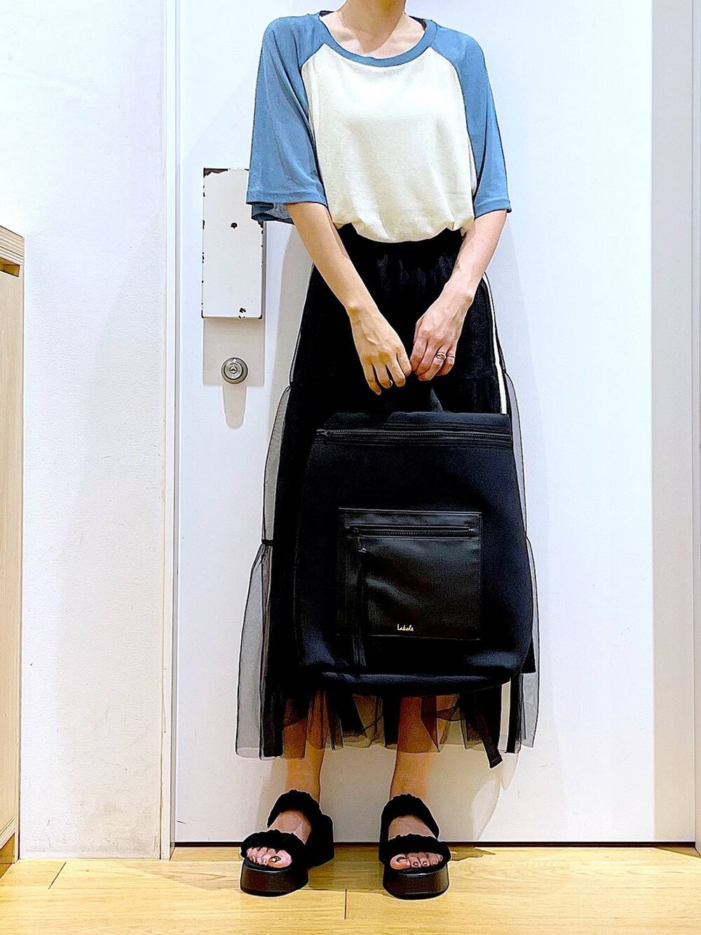 ブラック系のサンダル、ブルー系のTシャツ/カットソー、ブラック系のスカートを着用したレディースの夏コーディネートの6枚目の写真