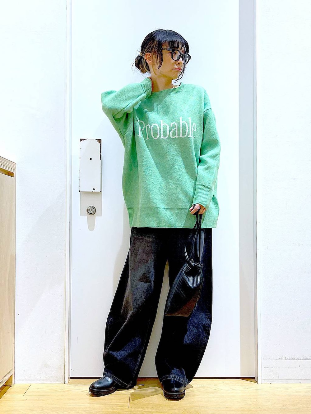 ブラック系のショルダーバッグ、ブラック系のブーツ、ブラック系のデニムパンツを着用したレディースの冬コーディネートの2枚目の写真