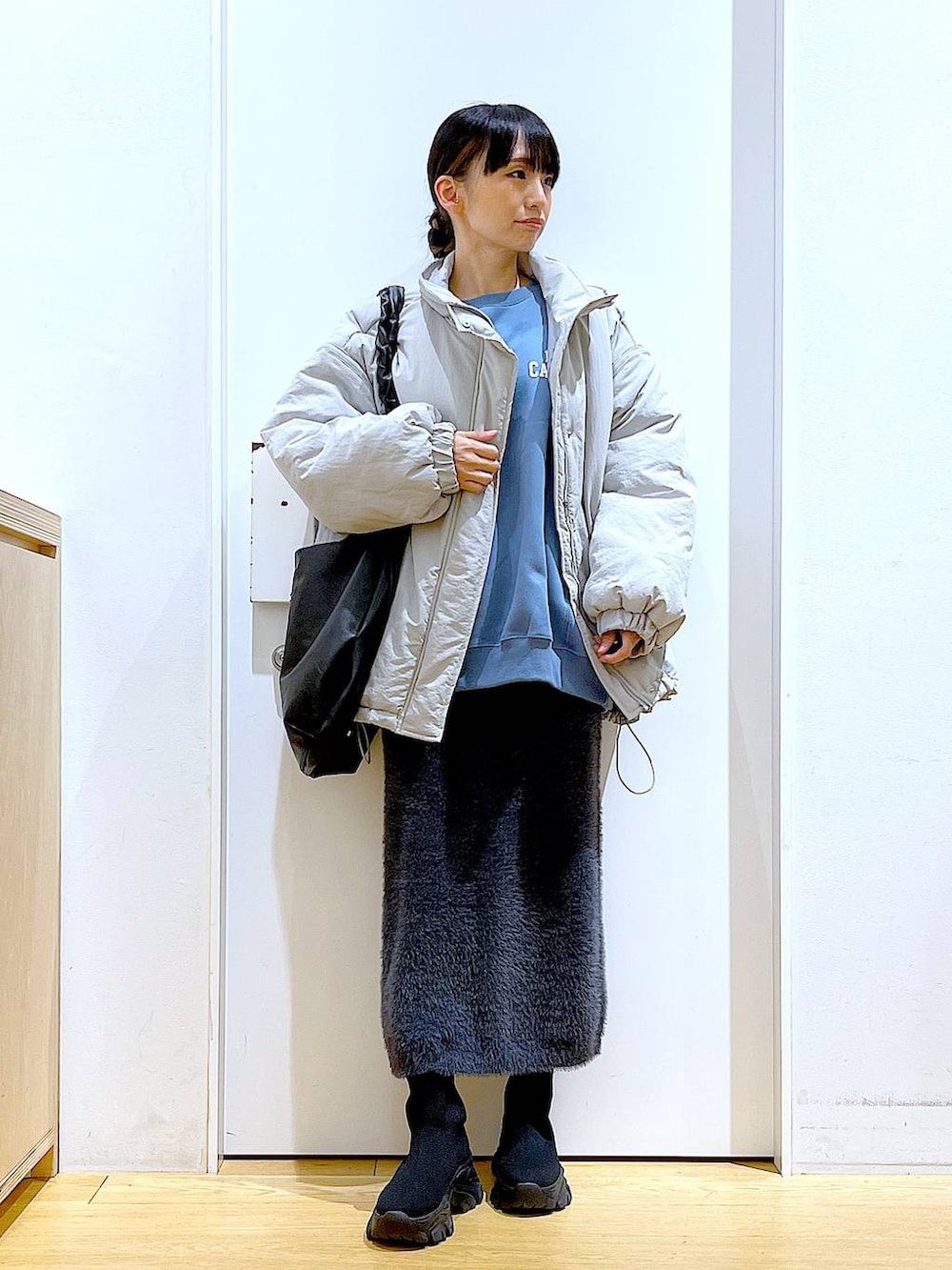 ブラック系のブーツ、ブルー系のスウェット、ブラック系のショルダーバッグを着用したレディースの冬コーディネートの2枚目の写真