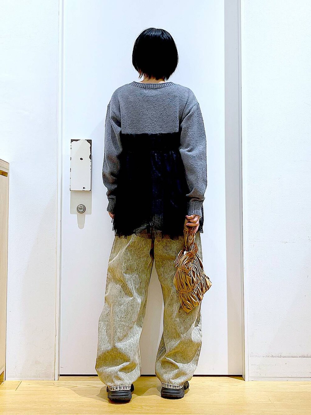 ブラック系のブーツ、イエロー系のショルダーバッグ、ベージュ系のデニムパンツを着用したレディースの秋コーディネートの5枚目の写真