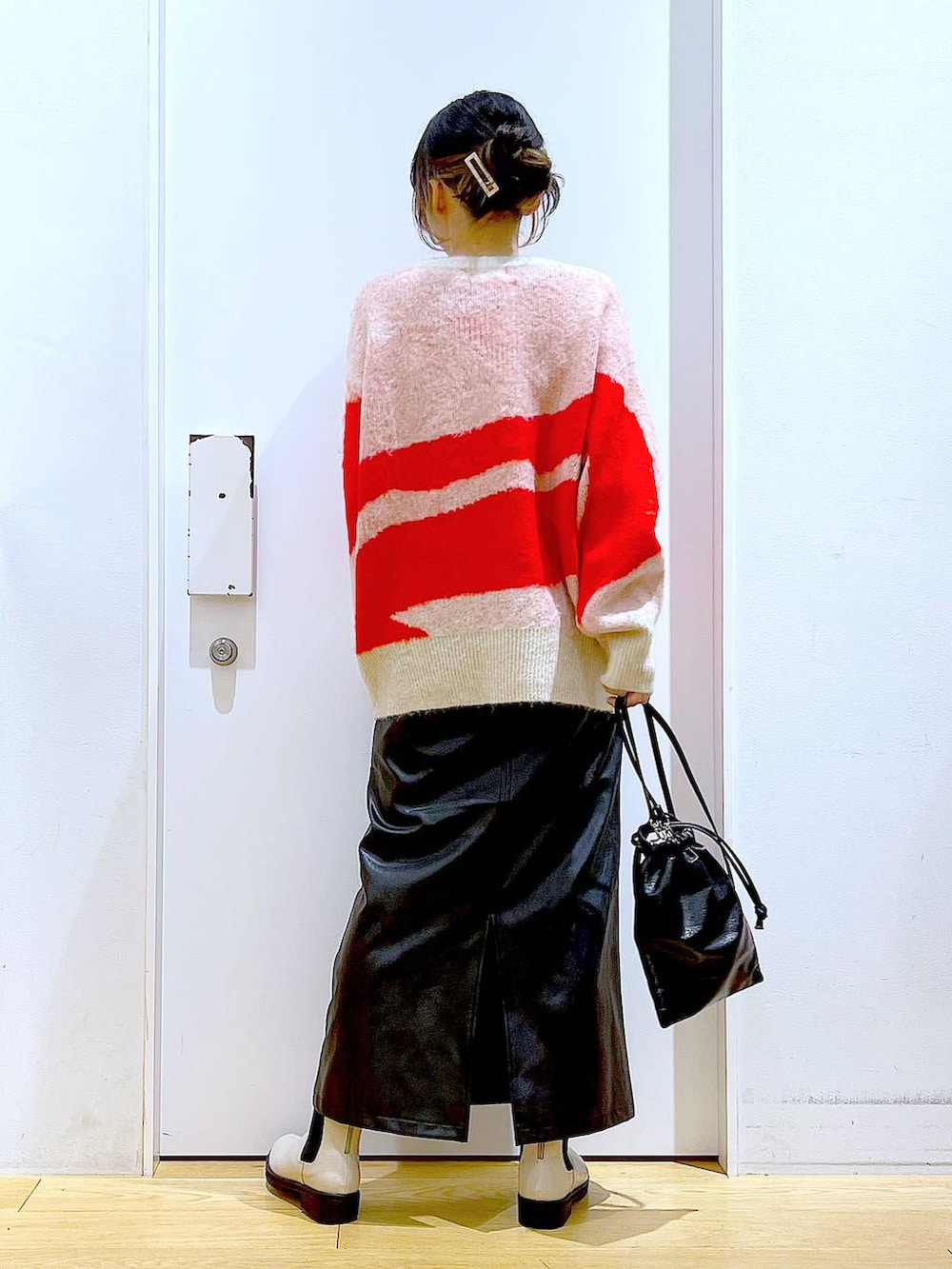 ベージュ系のブーツ、ブラック系のスカート、ブラック系のショルダーバッグを着用したレディースの冬コーディネートの5枚目の写真