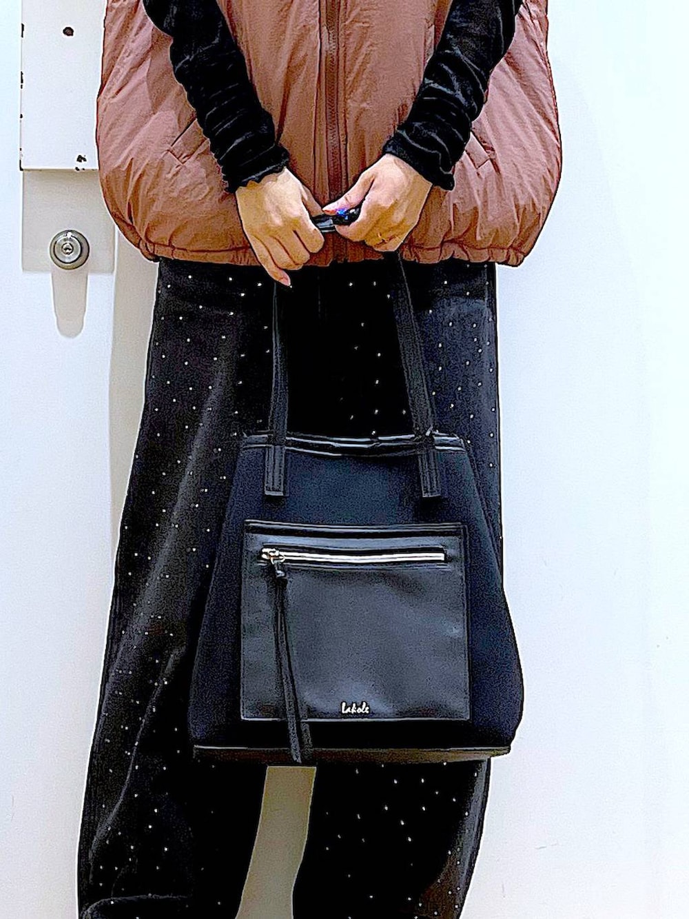 ブラウン系のベスト、ブラック系のトートバッグ、ブラック系のTシャツ/カットソーを着用したレディースの秋コーディネートの9枚目の写真