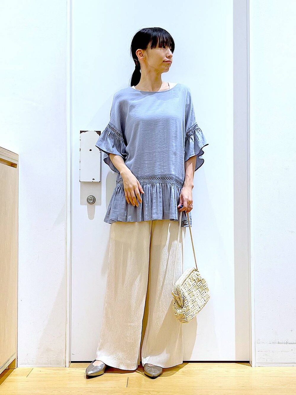 ブルー系のチュニック、その他のパンプス、ホワイト系のショルダーバッグを着用したレディースの春コーディネートの2枚目の写真