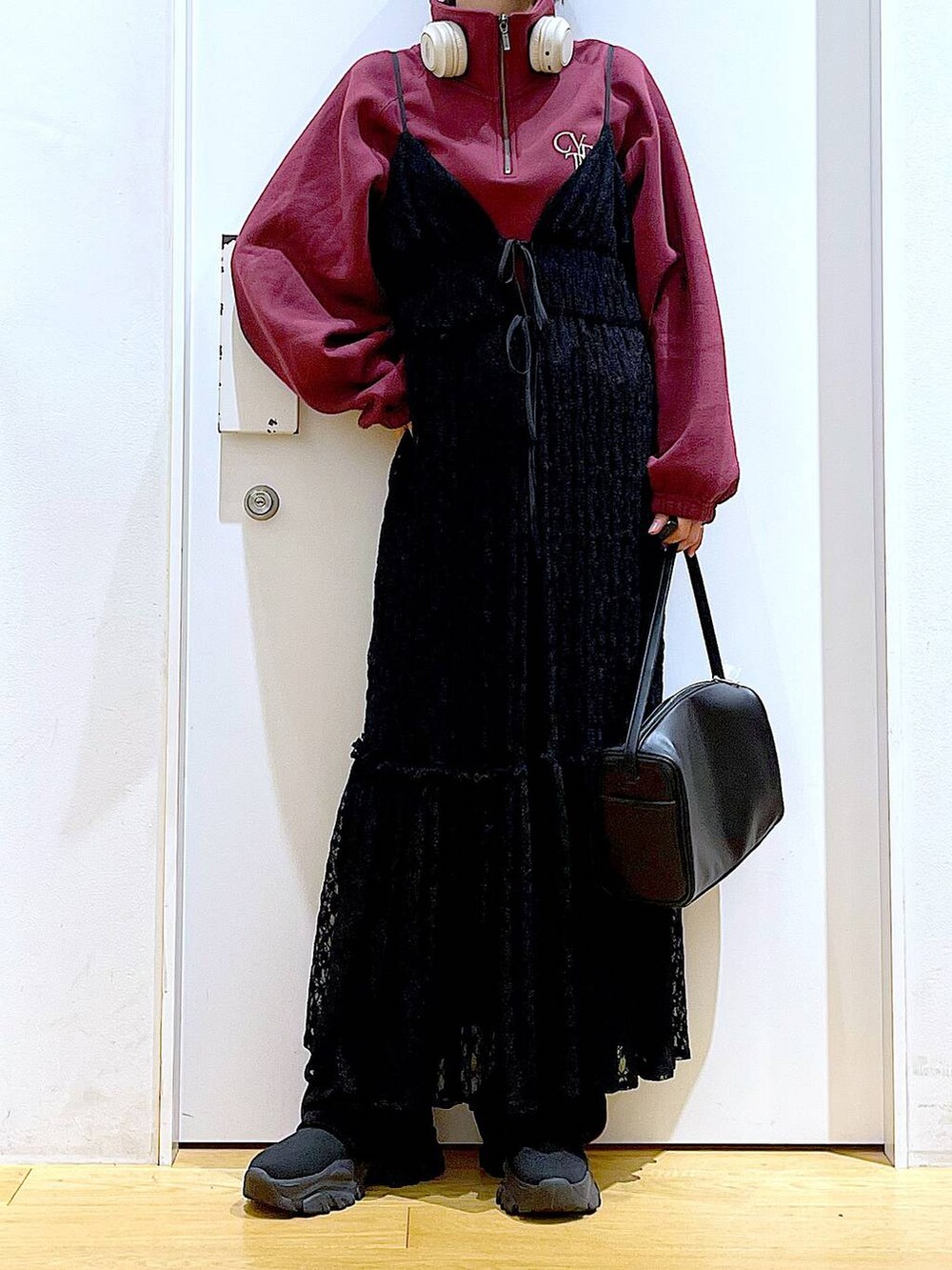 ブラック系のショルダーバッグ、ブラック系のワンピース、ブラック系のブーツを着用したレディースの冬コーディネートの6枚目の写真