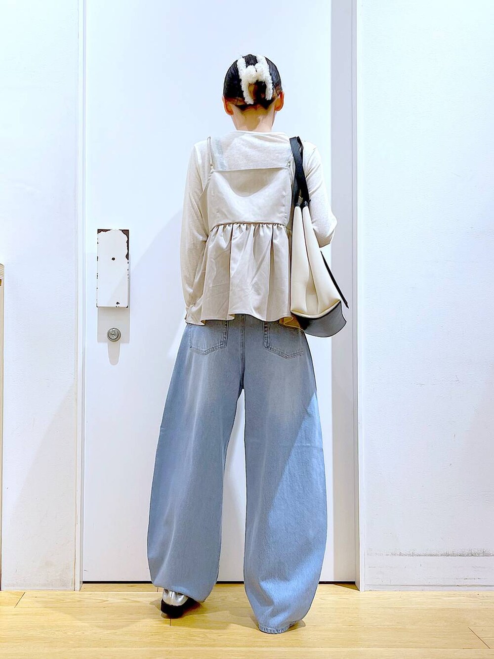 ブルー系のデニムパンツ、シルバー系のローファー、ホワイト系のトートバッグを着用したレディースの秋コーディネートの5枚目の写真