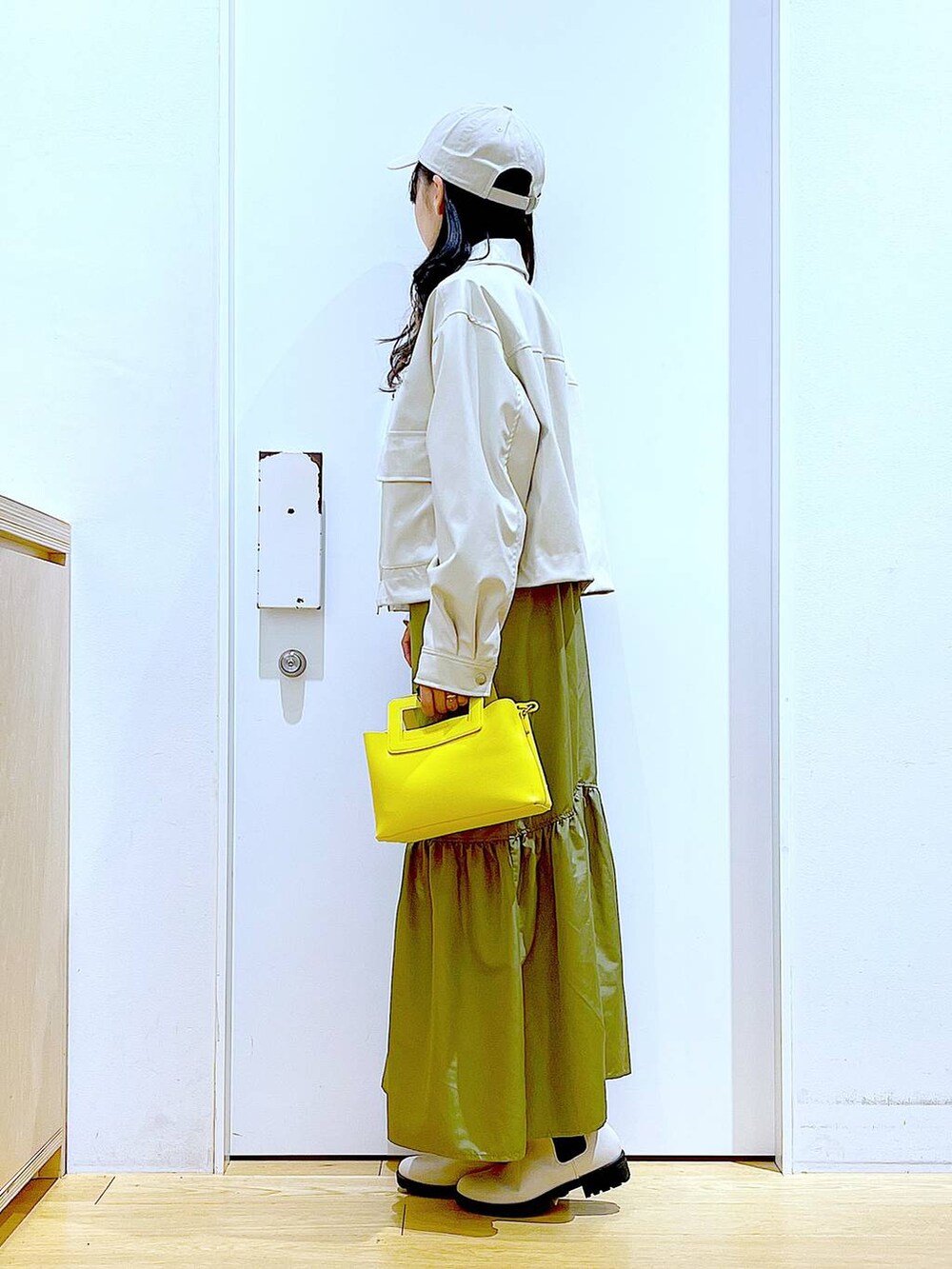 ベージュ系のブルゾン、ホワイト系のTシャツ/カットソー、ベージュ系のブーツを着用したレディースの春コーディネートの3枚目の写真