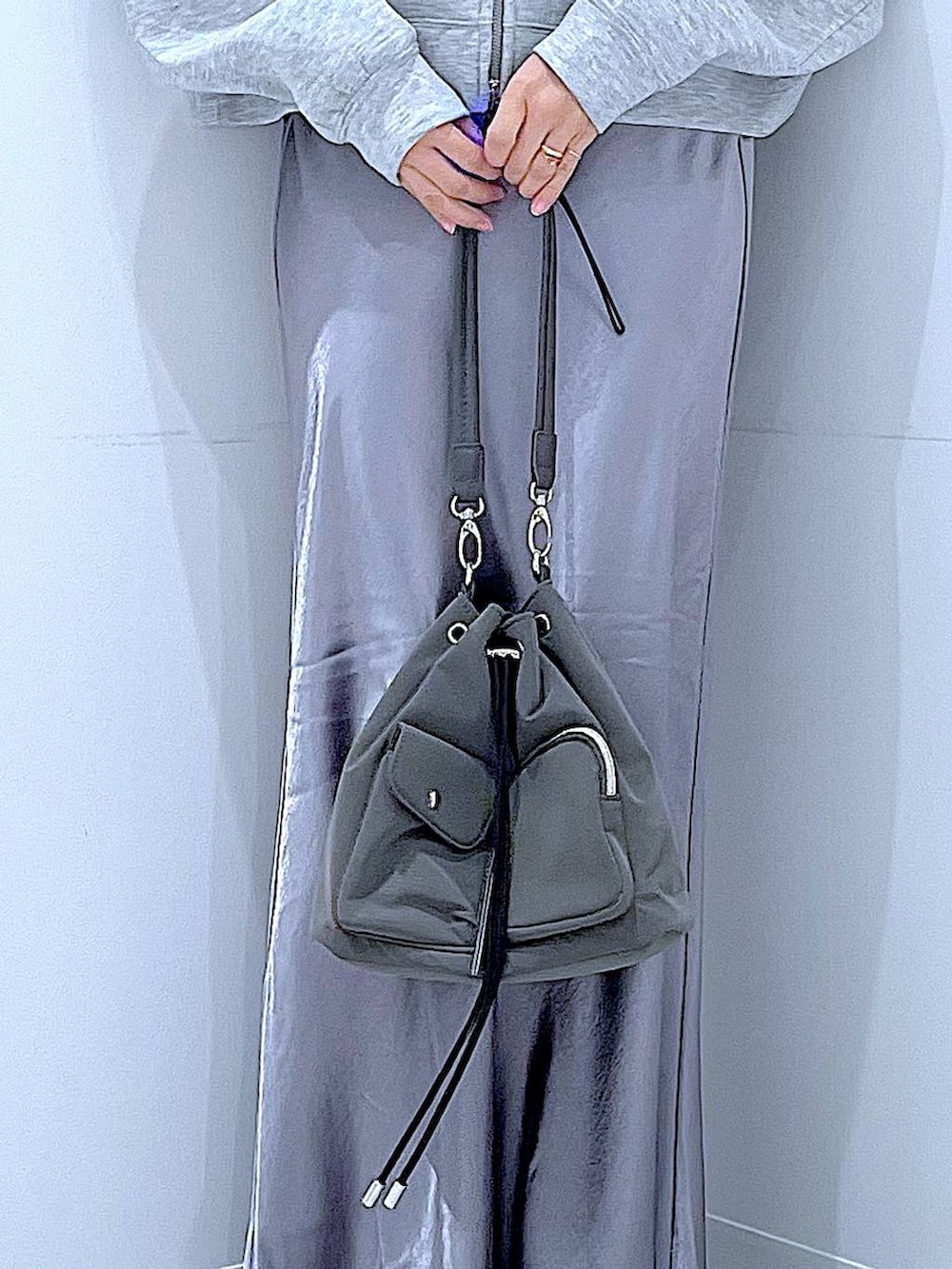 ブラック系のブーツ、グレー系のスカート、グレー系のパーカーを着用したレディースの春コーディネートの9枚目の写真