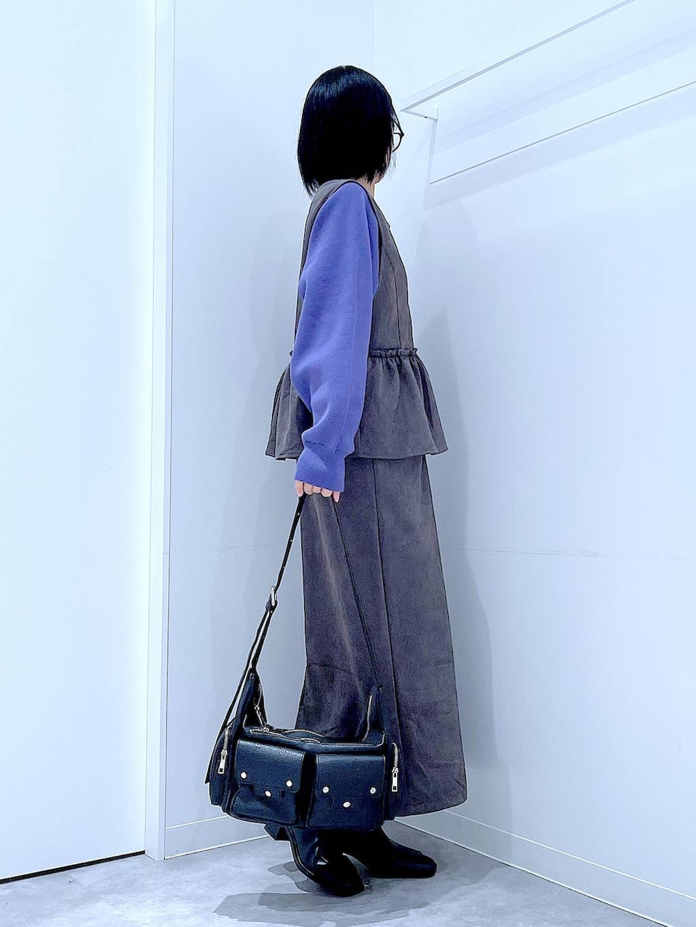 ブラック系のショルダーバッグ、ブルー系のニット/セーター、ブラック系のブーツを着用したレディースの秋コーディネートの4枚目の写真