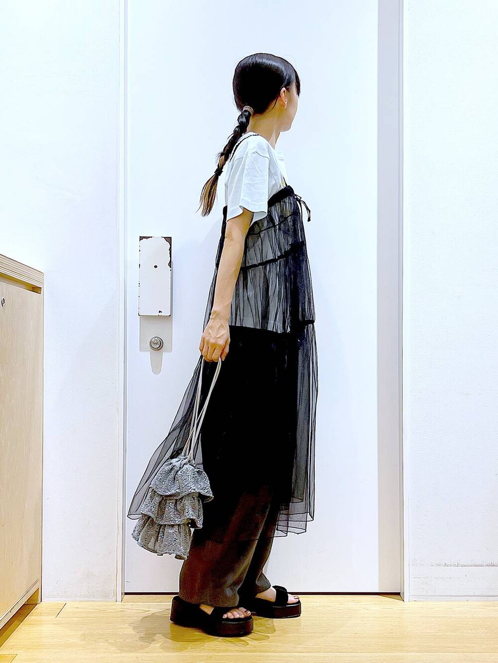 シルバー系のショルダーバッグ、グレー系のその他パンツ、ブラック系のサンダルを着用したレディースの夏コーディネートの4枚目の写真