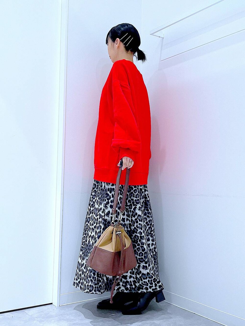 ベージュ系のショルダーバッグ、ブラック系のブーツ、グレー系のスカートを着用したレディースの秋コーディネートの3枚目の写真