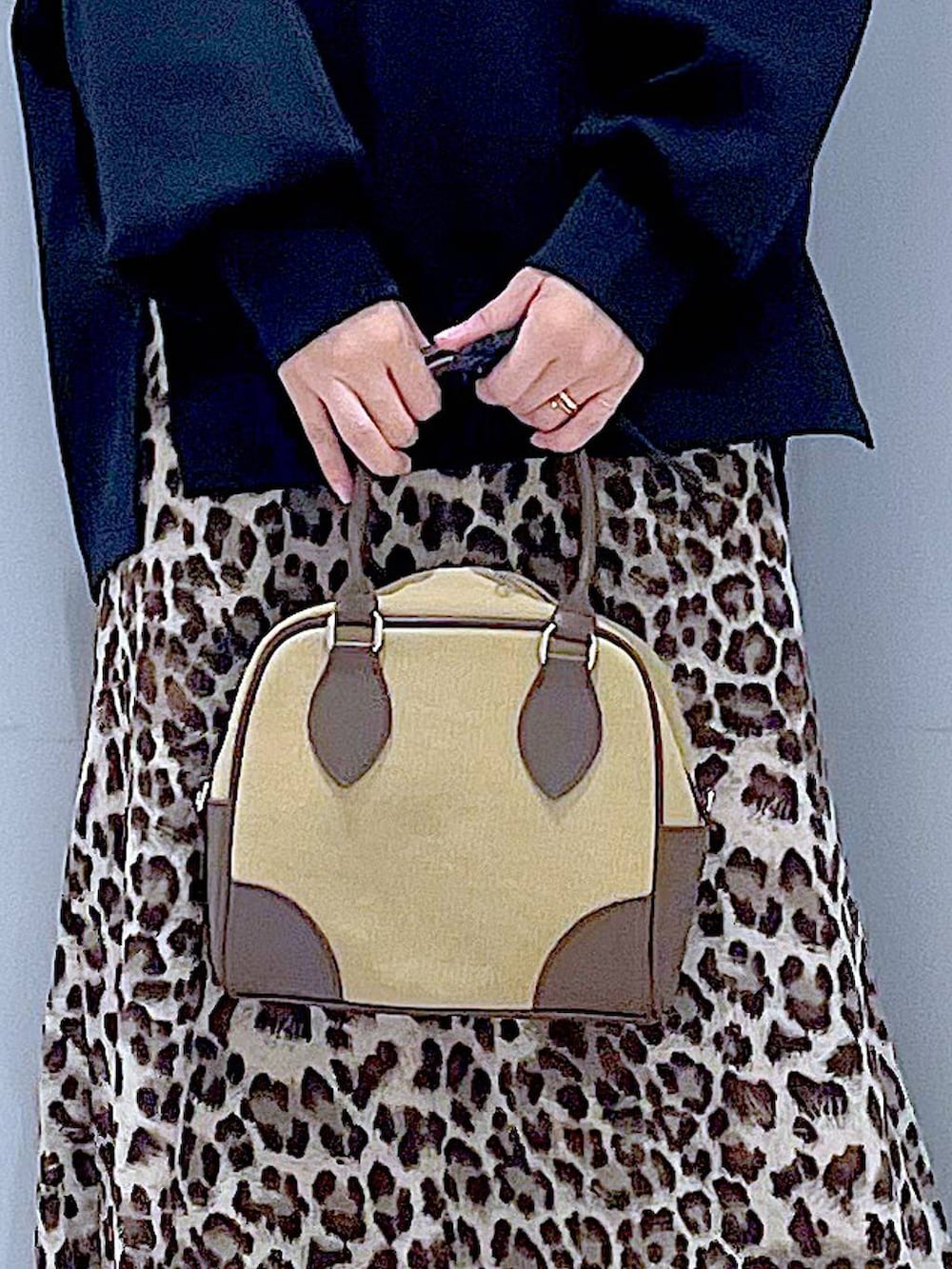 イエロー系のスリッポン、ベージュ系のハンドバッグ、ブラウン系のスカートを着用したレディースの秋コーディネートの9枚目の写真