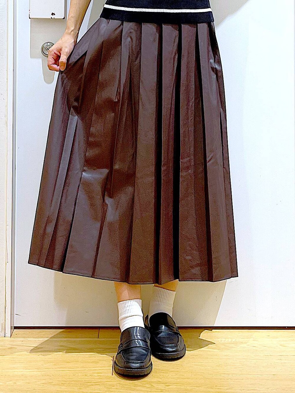 ホワイト系のショルダーバッグ、ブラック系のローファー、ブラック系のニット/セーターを着用したレディースの秋コーディネートの8枚目の写真