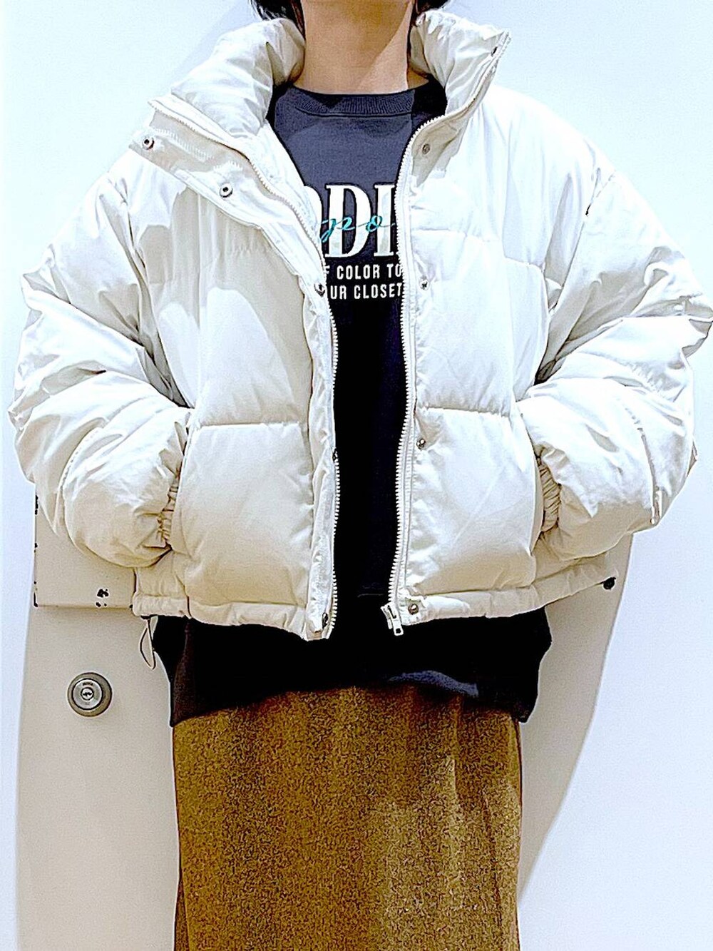 ベージュ系のブルゾン、ブラウン系のショルダーバッグ、ブラック系のブーツを着用したレディースの冬コーディネートの7枚目の写真