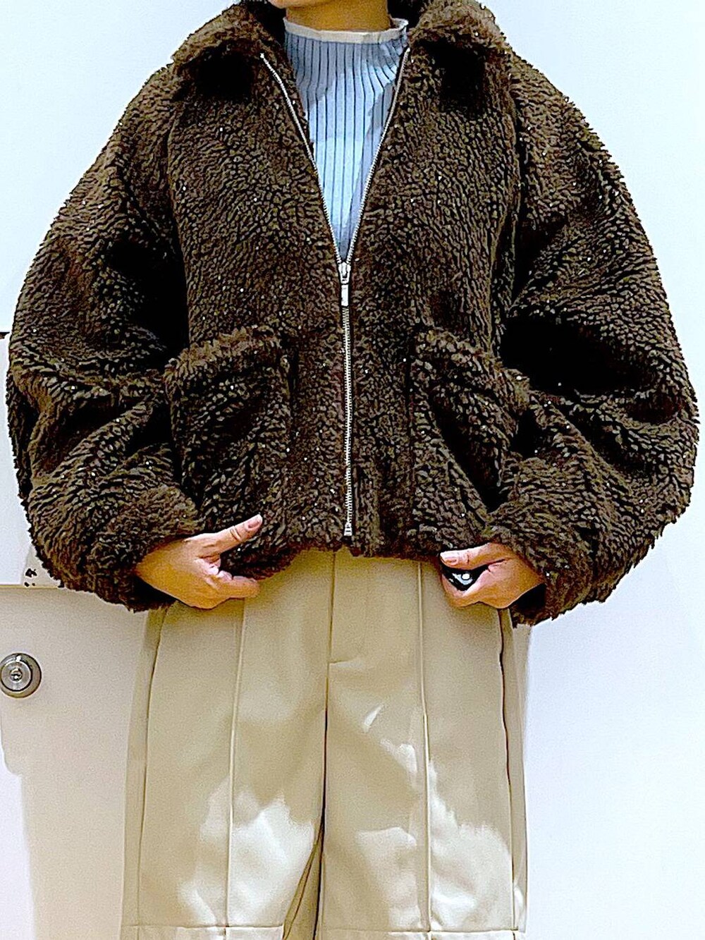 ブルー系のニット/セーター、ブラック系のトートバッグ、ブラック系のブーツを着用したレディースの冬コーディネートの7枚目の写真