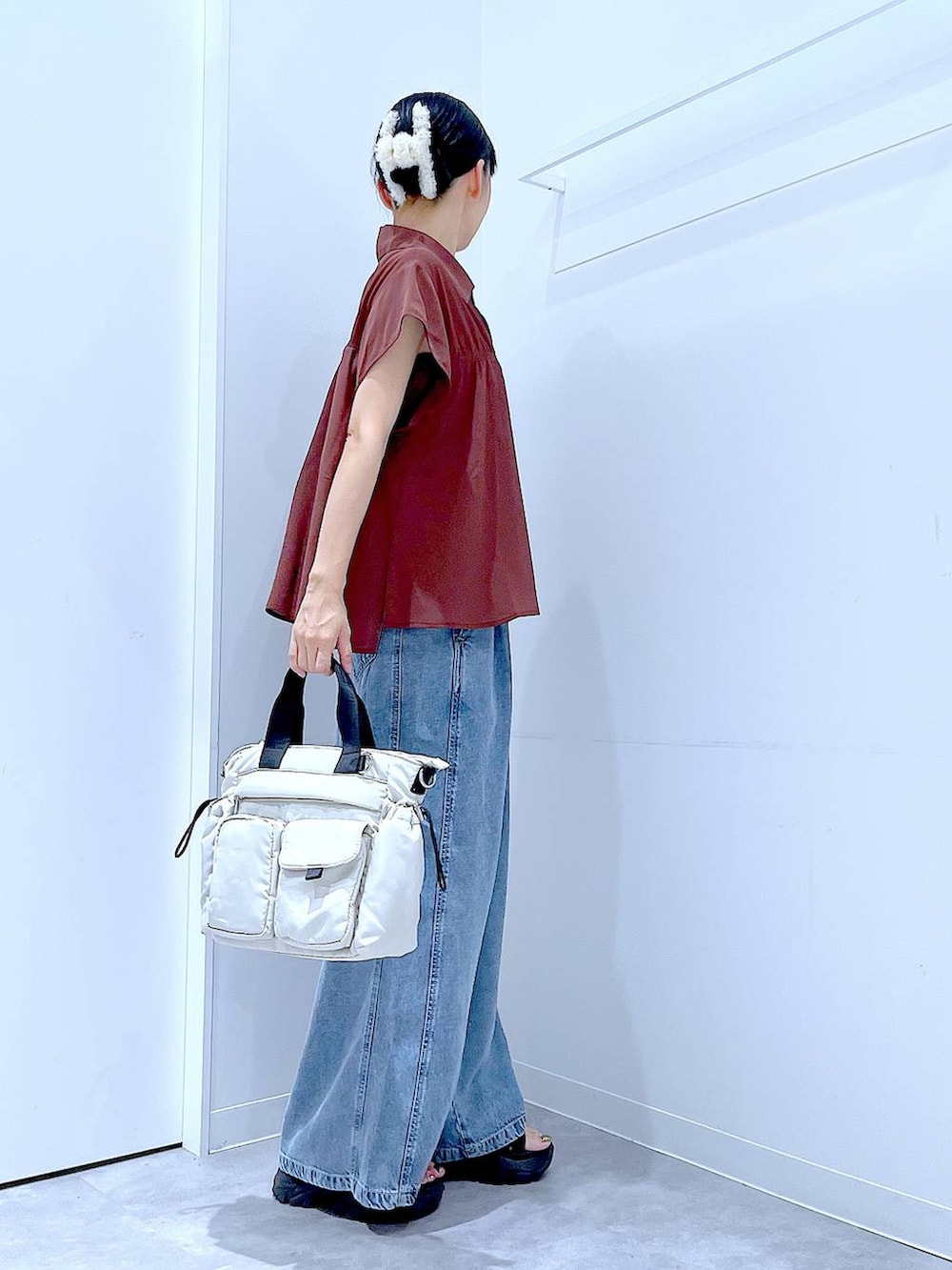 ホワイト系のトートバッグ、ブルー系のデニムパンツ、ブラウン系のシャツ/ブラウスを着用したレディースの夏コーディネートの4枚目の写真