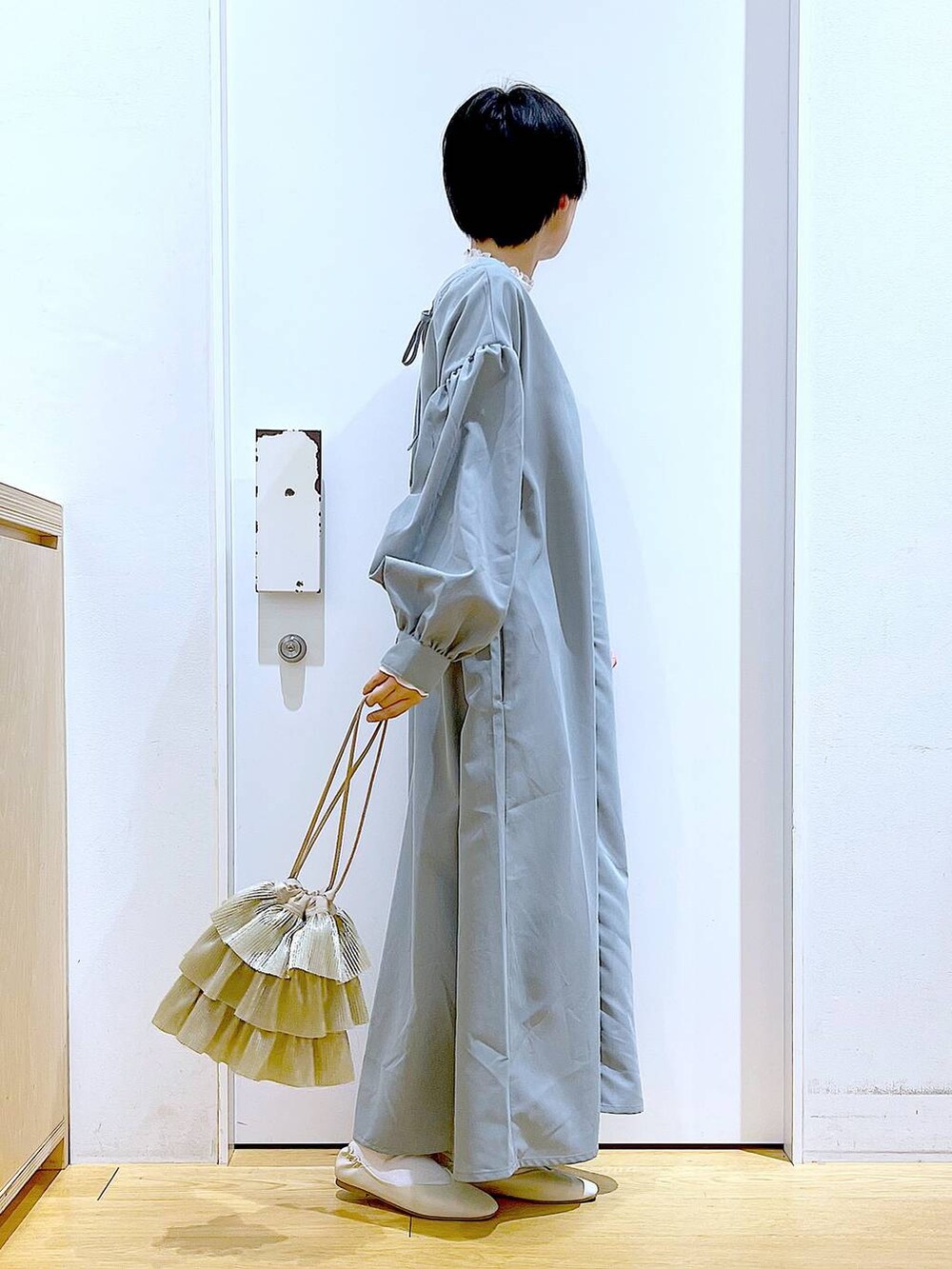 ベージュ系のTシャツ/カットソー、ホワイト系のパンプス、ベージュ系のショルダーバッグを着用したレディースの春コーディネートの4枚目の写真