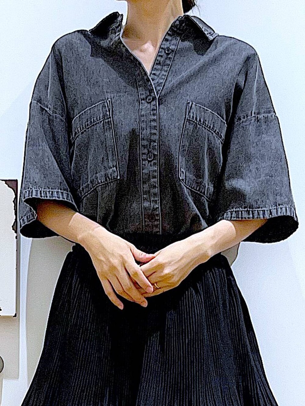 シルバー系のショルダーバッグ、ブラック系のスカート、ブラック系のサンダルを着用したレディースの夏コーディネートの7枚目の写真