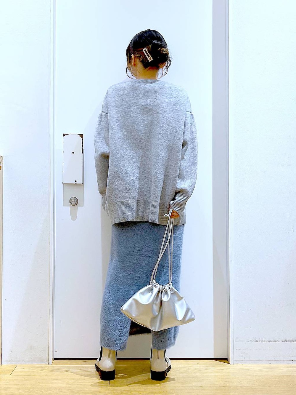 ベージュ系のブーツ、シルバー系のショルダーバッグ、ブルー系のスカートを着用したレディースの冬コーディネートの5枚目の写真