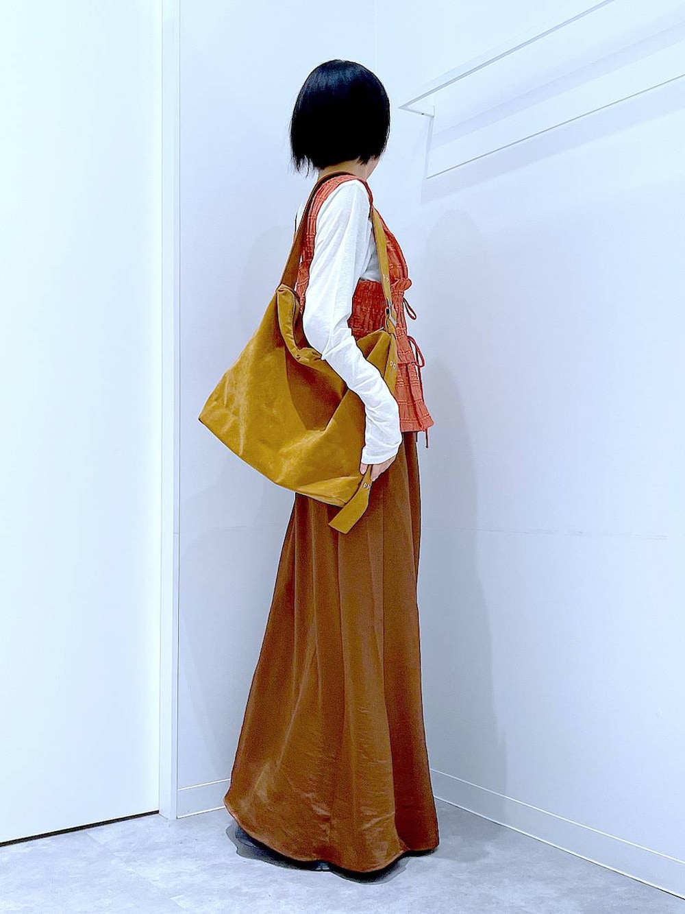 ホワイト系のTシャツ/カットソー、ブラック系のローファー、ブラウン系のスカートを着用したレディースの秋コーディネートの4枚目の写真