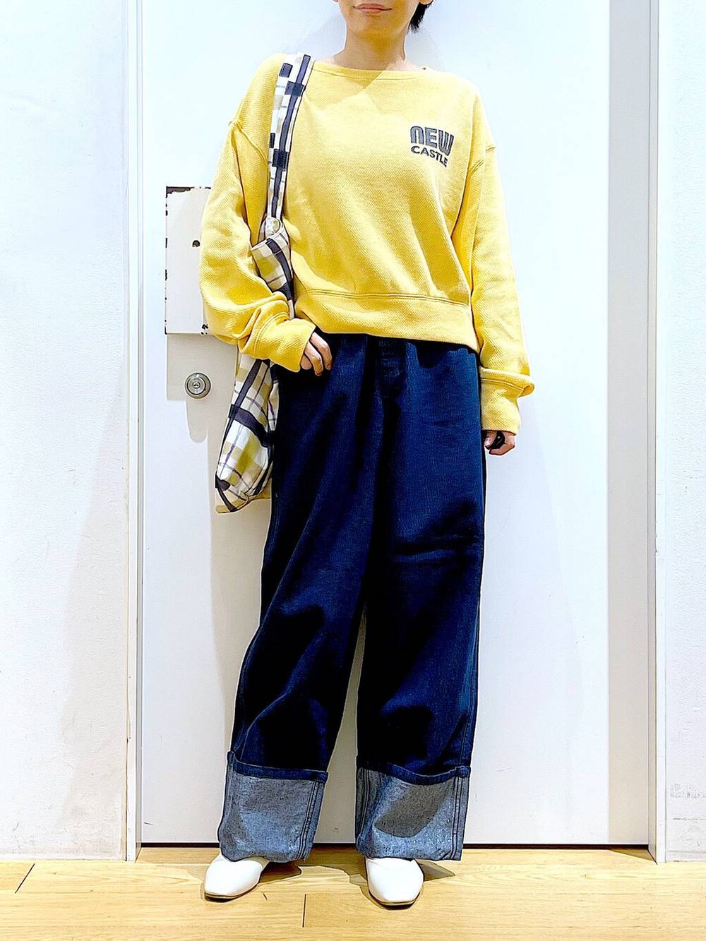 ホワイト系のパンプス、ブルー系のデニムパンツ、その他のトートバッグを着用したレディースの冬コーディネートの6枚目の写真