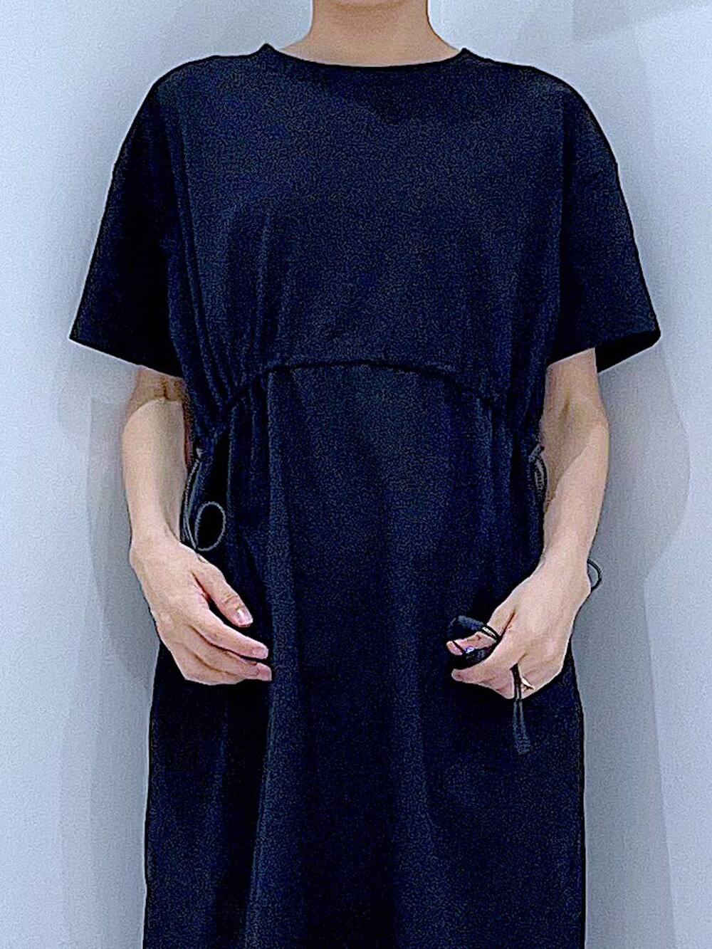 ブラック系のサンダル、ブラック系のワンピース、グリーン系のトートバッグを着用したレディースの夏コーディネートの7枚目の写真