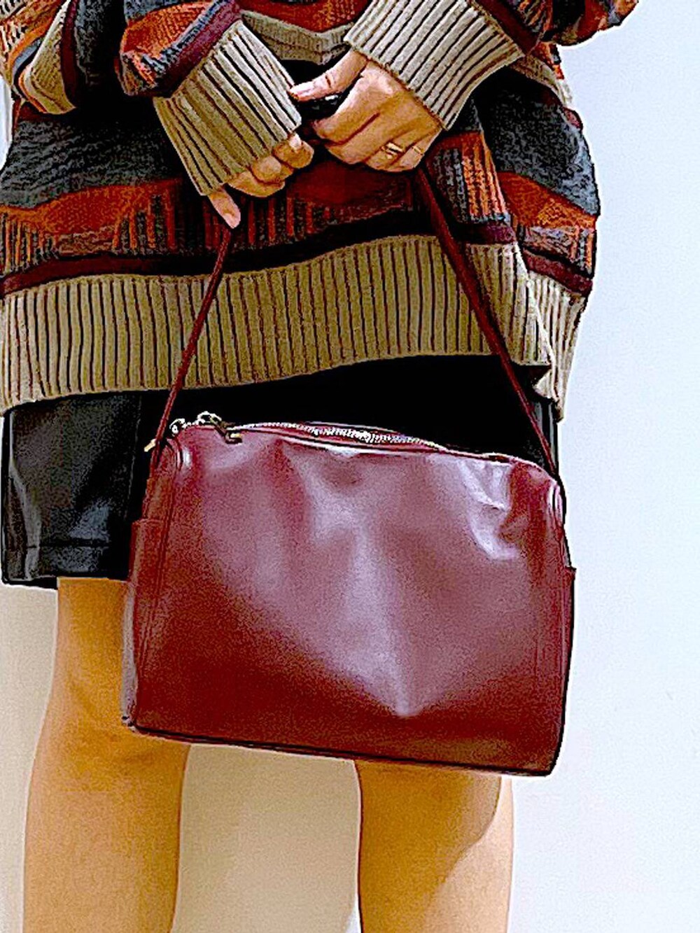 レッド系のショルダーバッグ、ブラック系のブーツ、ブラック系のその他パンツを着用したレディースの冬コーディネートの9枚目の写真