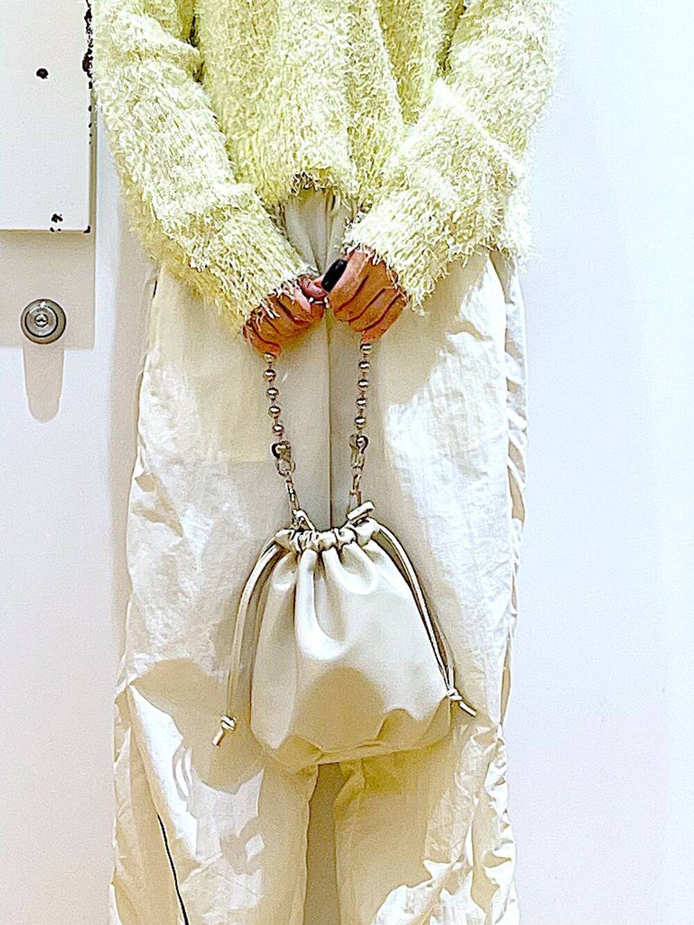 ベージュ系のショルダーバッグ、ホワイト系のスニーカー、イエロー系のカーディガン/ボレロを着用したレディースの秋コーディネートの9枚目の写真