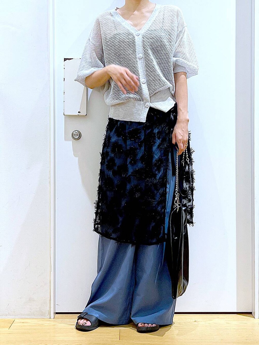 ブラック系のショルダーバッグ、グレー系のカーディガン/ボレロ、ブルー系のその他パンツを着用したレディースの夏コーディネートの6枚目の写真