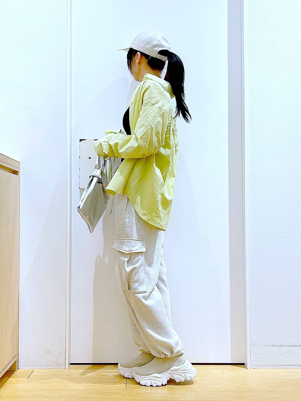 シルバー系のショルダーバッグ、ベージュ系のスウェットパンツ、グリーン系のシャツ/ブラウスを着用したレディースの春コーディネートの3枚目の写真