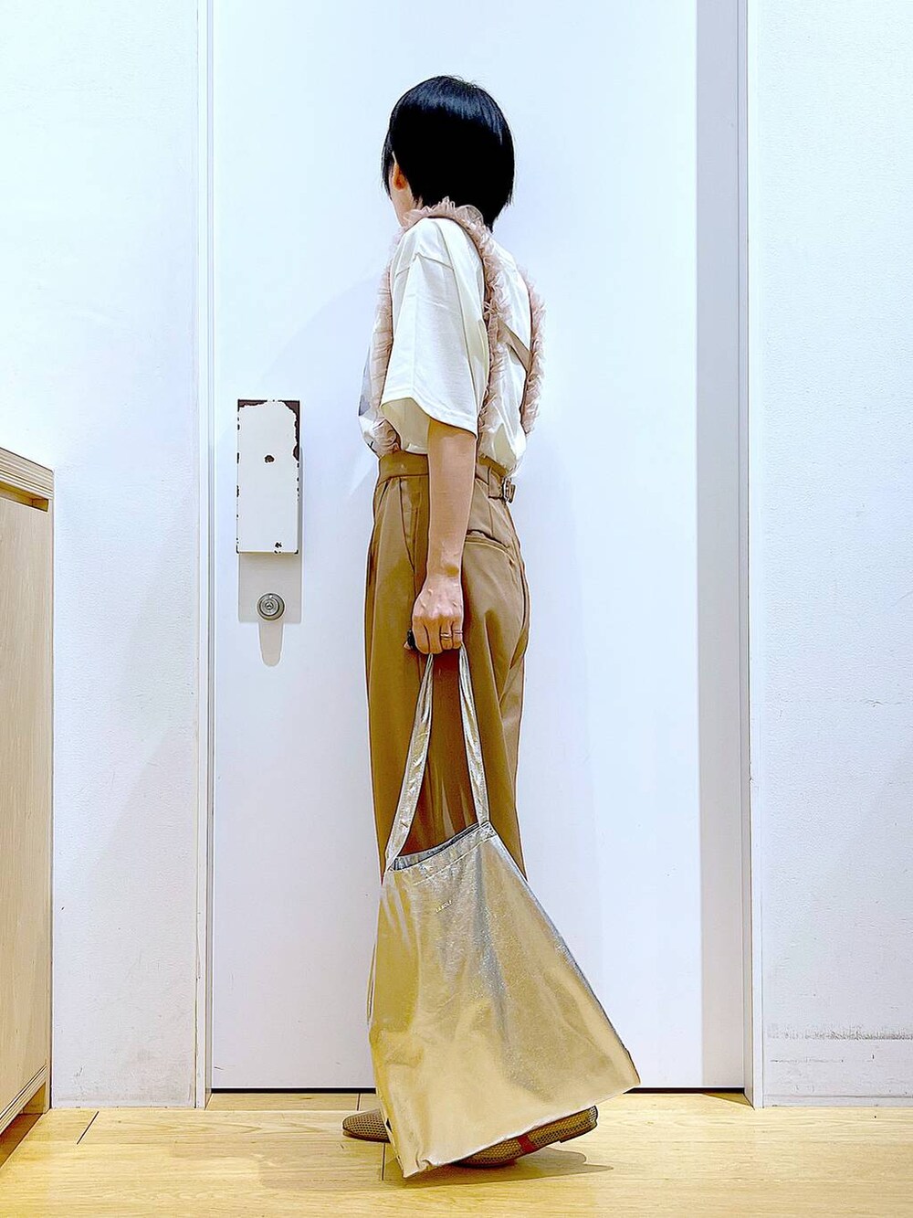 シルバー系のトートバッグ、ベージュ系のパンプス、ブラウン系のその他パンツを着用したレディースの春コーディネートの3枚目の写真