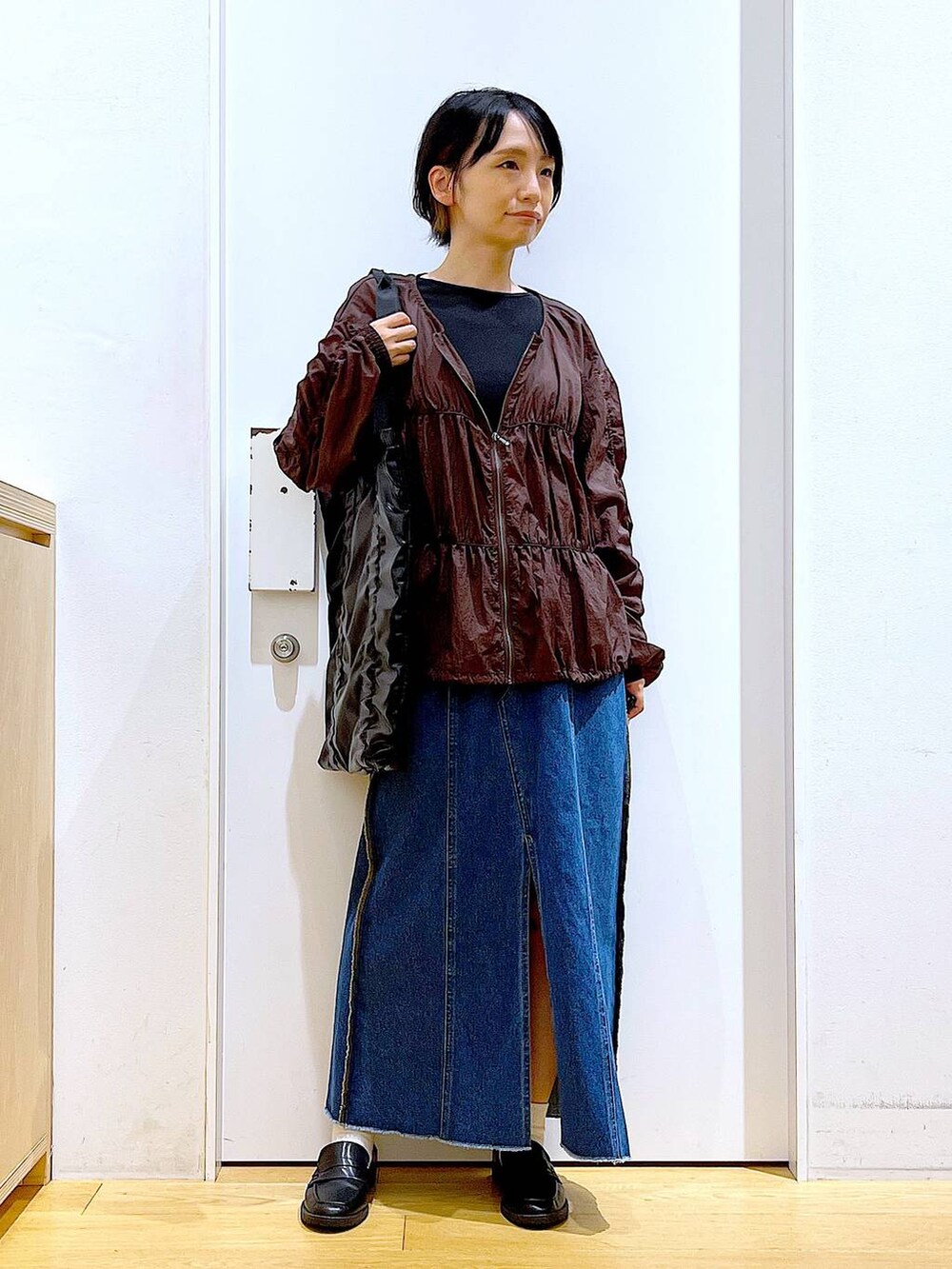 ブラック系のローファー、ブルー系のデニムスカート、ブラック系のTシャツ/カットソーを着用したレディースの秋コーディネートの2枚目の写真