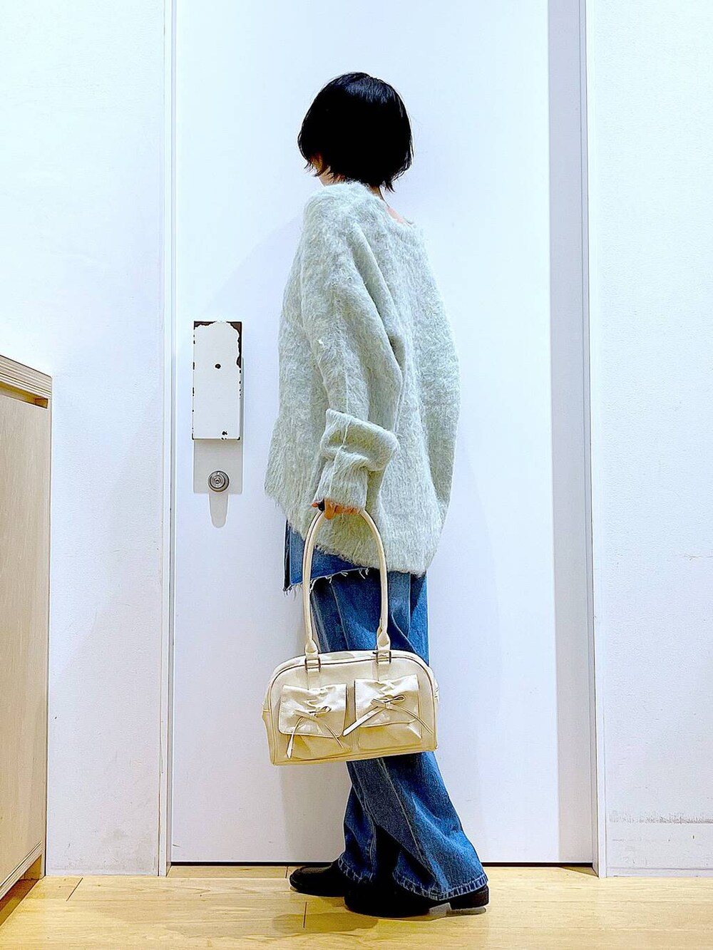 グリーン系のカーディガン/ボレロ、ブラック系のローファー、ブルー系のデニムパンツを着用したレディースの秋コーディネートの3枚目の写真