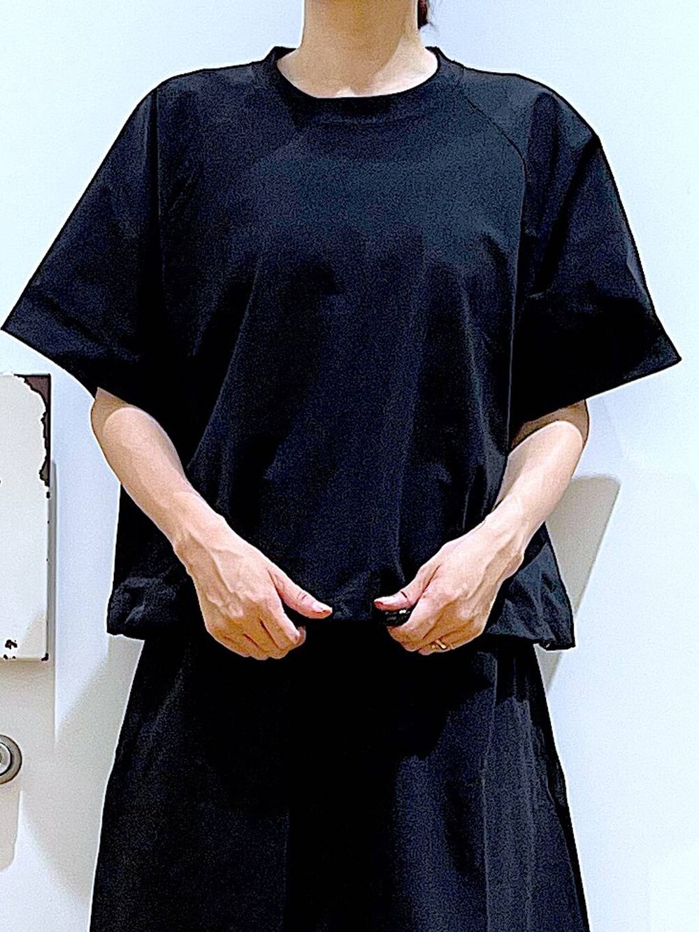 ブラック系のサンダル、ブラック系のTシャツ/カットソー、ブラック系のスカートを着用したレディースの夏コーディネートの7枚目の写真