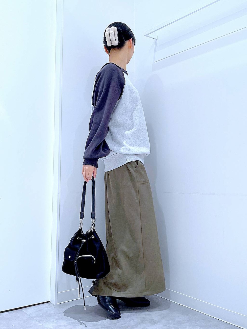 ブラック系のショルダーバッグ、グレー系のニット/セーター、ブラック系のブーツを着用したレディースの冬コーディネートの4枚目の写真