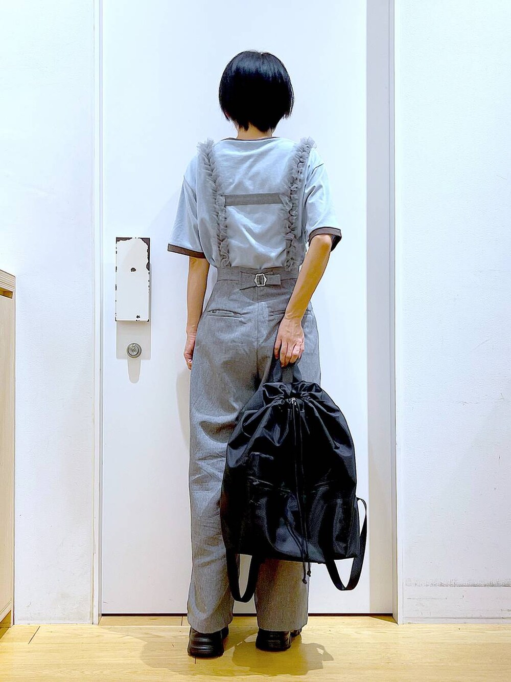 ブラック系のスニーカー、ブラック系のバックパック/リュック、グレー系のその他パンツを着用したレディースの春コーディネートの5枚目の写真