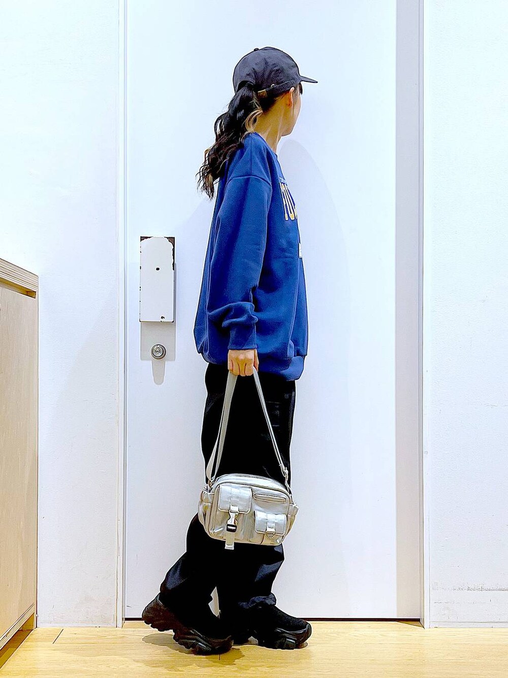 ブラック系のカーゴパンツ、ブラック系のスニーカー、ブルー系のスウェットを着用したレディースの冬コーディネートの4枚目の写真