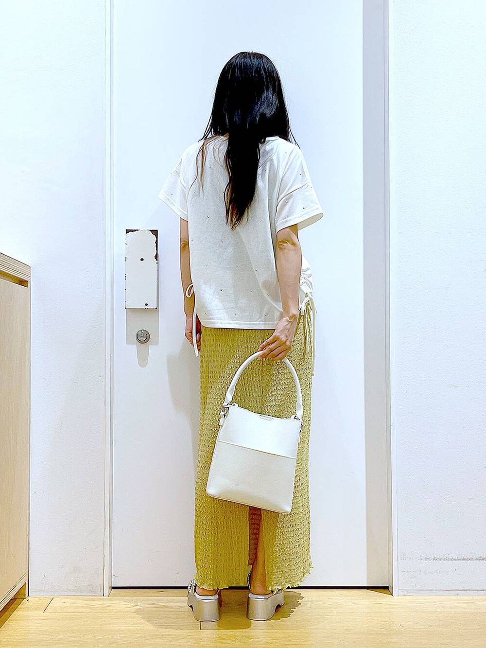 シルバー系のサンダル、ホワイト系のショルダーバッグ、グリーン系のスカートを着用したレディースの夏コーディネートの5枚目の写真