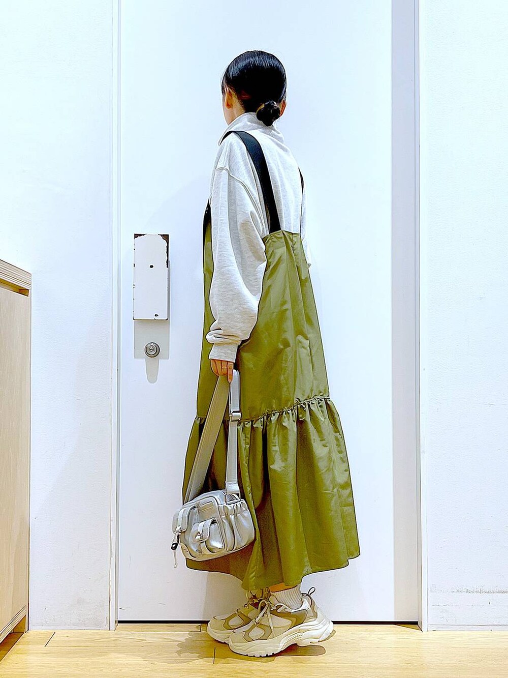 ベージュ系のスウェット、ベージュ系のスニーカー、シルバー系のショルダーバッグを着用したレディースの春コーディネートの3枚目の写真