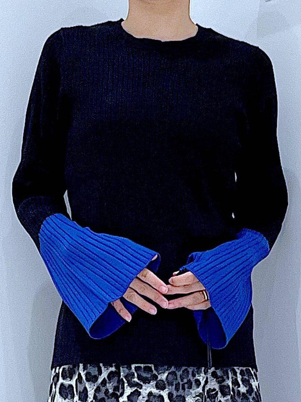 ブラック系のニット/セーター、ブラック系のブーツ、グレー系のスカートを着用したレディースの秋コーディネートの7枚目の写真