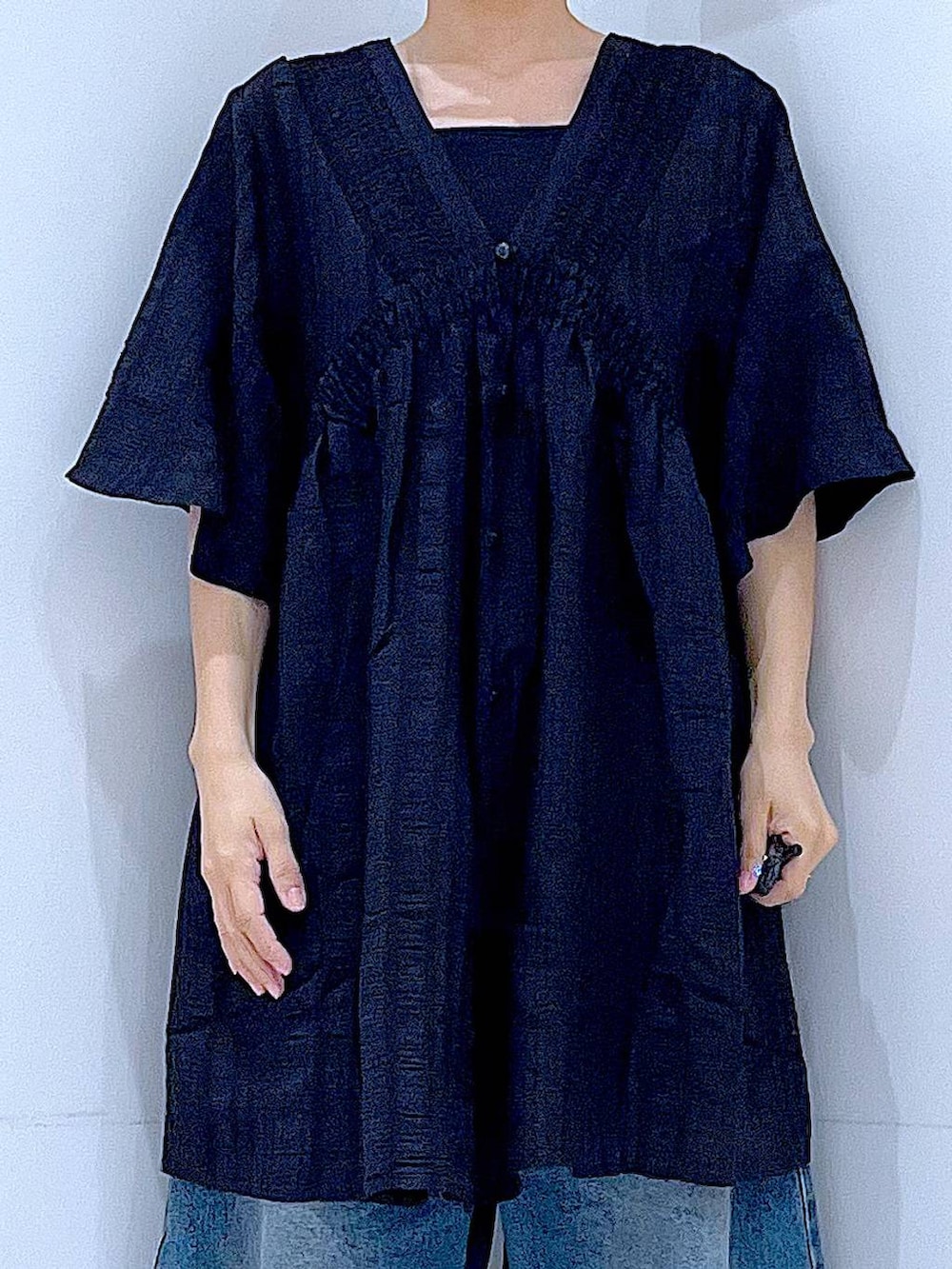 ブルー系のデニムパンツ、ブラック系のスニーカー、ベージュ系のショルダーバッグを着用したレディースの春コーディネートの7枚目の写真