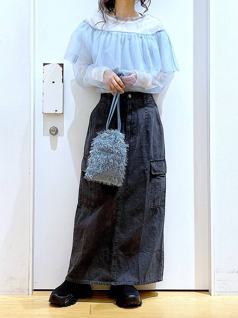 グレー系のデニムスカート、ブラック系のスニーカー、ブルー系のその他トップスを着用したレディースの春コーディネートの6枚目の写真