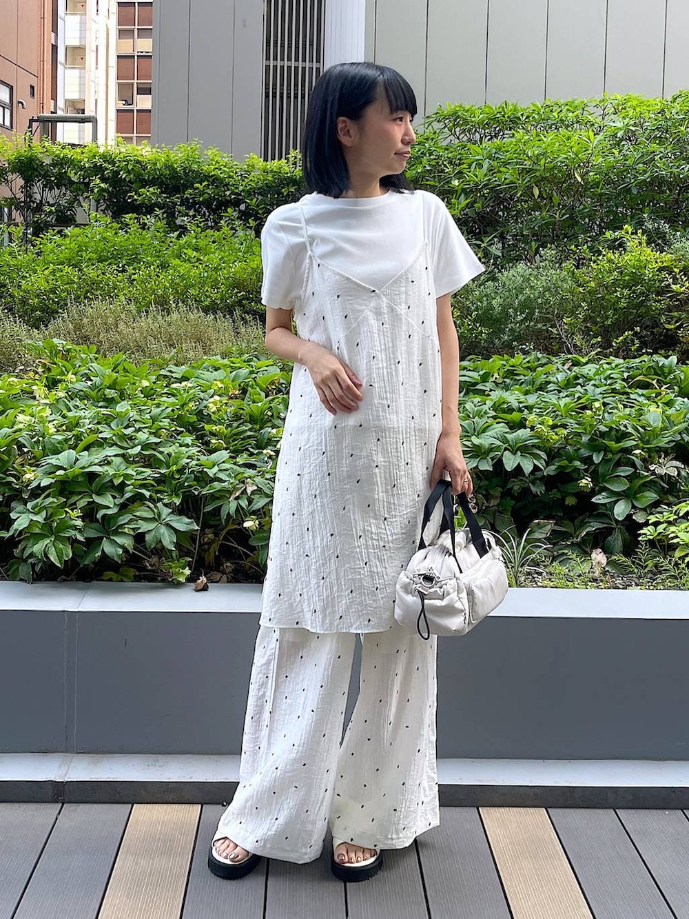 ホワイト系のサンダル、ホワイト系のTシャツ/カットソー、ホワイト系のショルダーバッグを着用したレディースの夏コーディネートの2枚目の写真