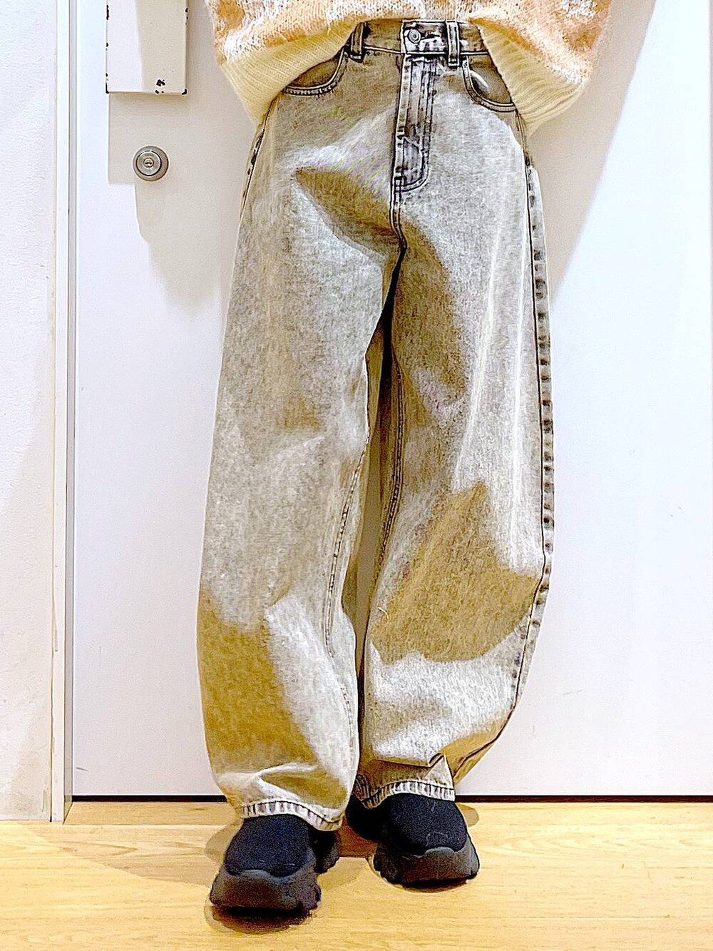 ブラック系のブーツ、ベージュ系のショルダーバッグ、ベージュ系のデニムパンツを着用したレディースの冬コーディネートの8枚目の写真