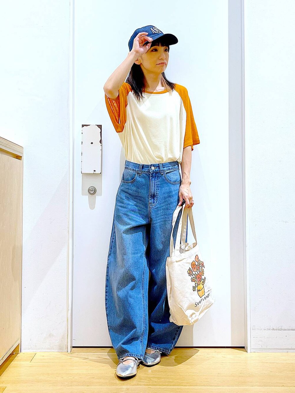 その他のトートバッグ、オレンジ系のTシャツ/カットソー、ブルー系のデニムパンツを着用したレディースの夏コーディネートの2枚目の写真