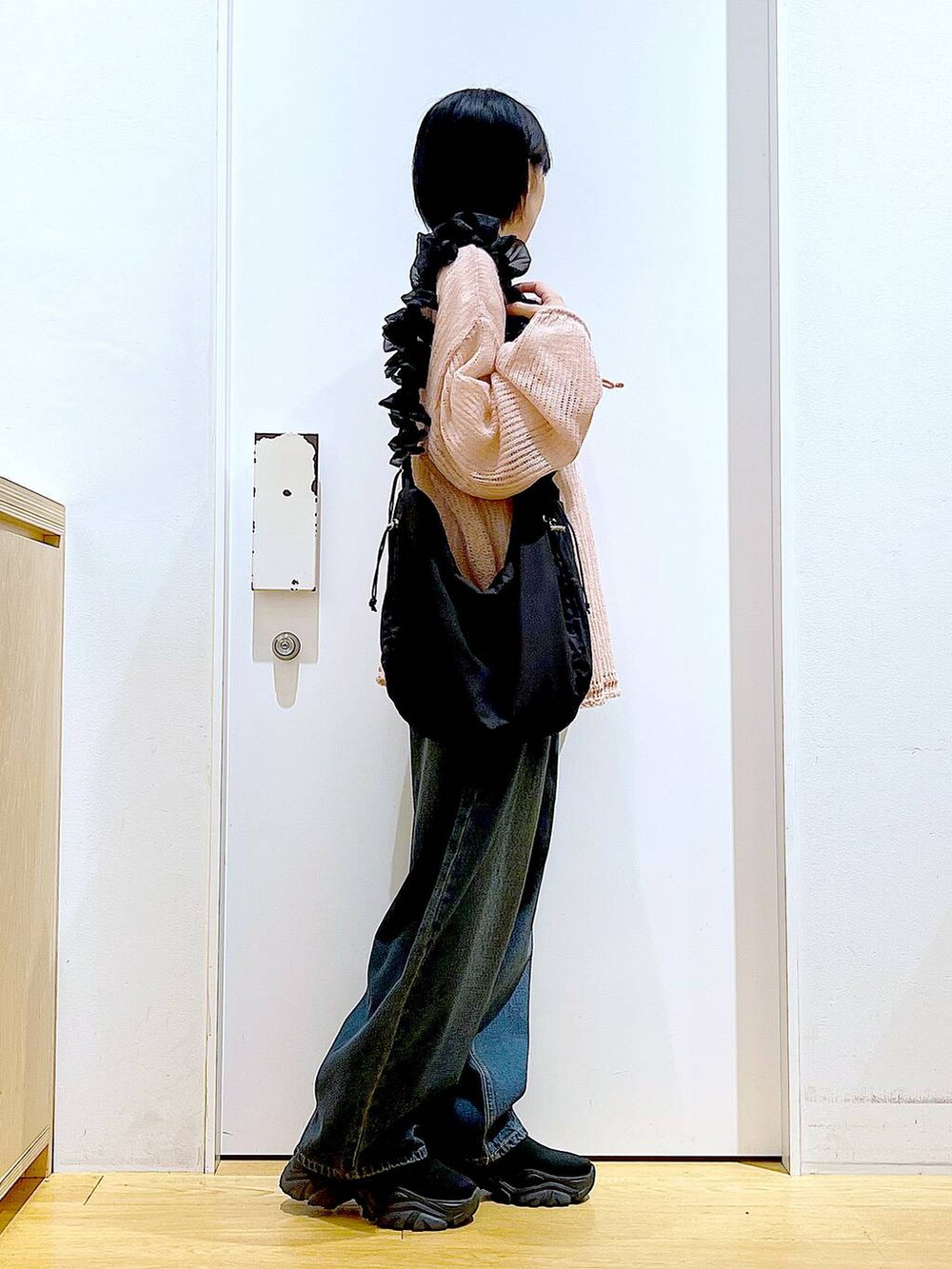 ブラック系のショルダーバッグ、ブラック系のブーツ、ピンク系のニット/セーターを着用したレディースの冬コーディネートの4枚目の写真