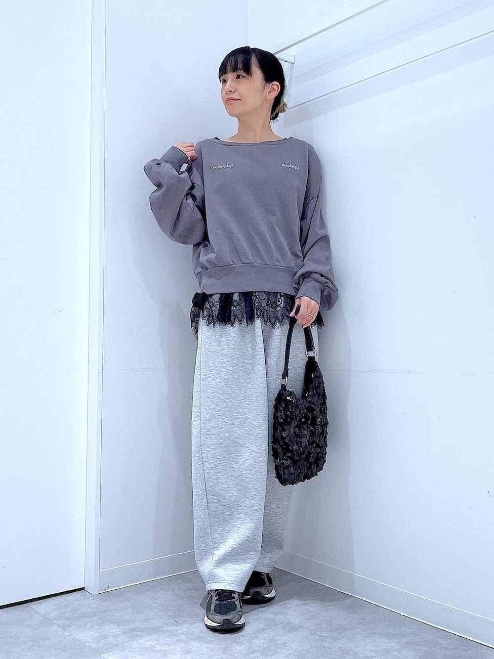 グレー系のスウェット、ブラック系のショルダーバッグ、ブラック系のタンクトップを着用したレディースの春コーディネートの2枚目の写真