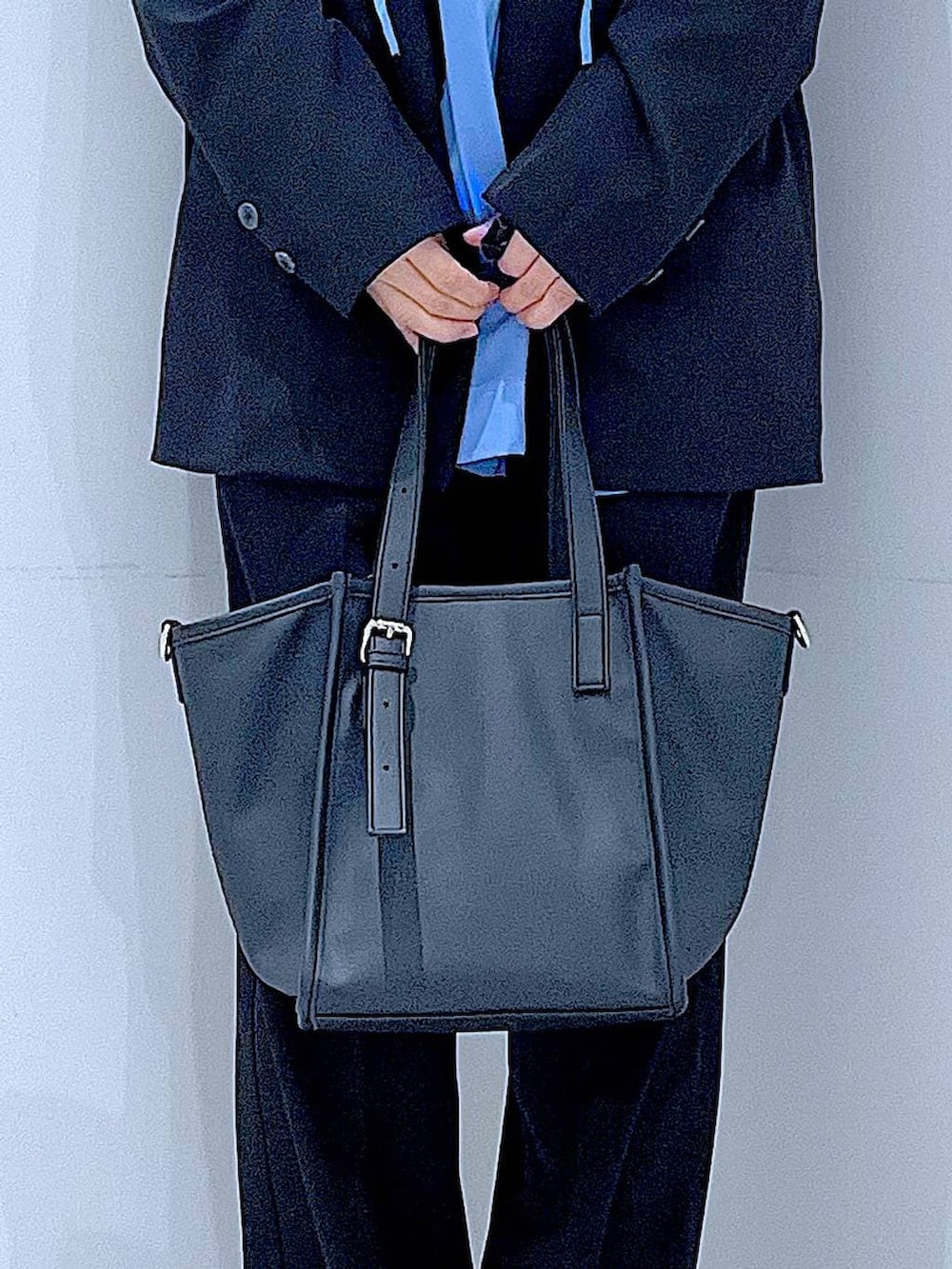 ブラック系のブーツ、ブラック系のトートバッグ、ブラック系のノーカラージャケットを着用したレディースの冬コーディネートの9枚目の写真