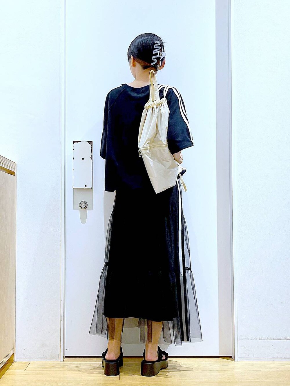 ホワイト系のバックパック/リュック、ブラック系のサンダル、ブラック系のスカートを着用したレディースの夏コーディネートの5枚目の写真